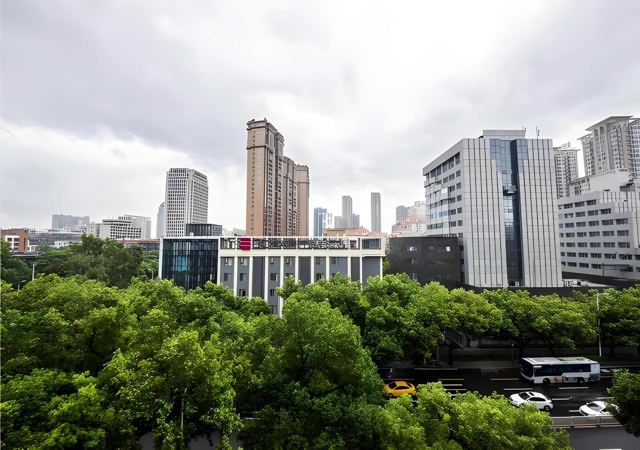 A cityscape with modern buildings, a bus, and a parking area.