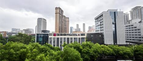 A cityscape with modern buildings, a bus, and a parking area.