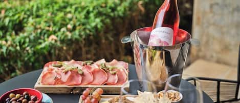Una mesa dispuesta con diferentes alimentos y una botella de vino, probablemente para una comida o reunión.