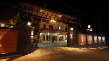 A hotel entrance with a gated driveway, a covered outdoor area, and a sign indicating the hotel name.