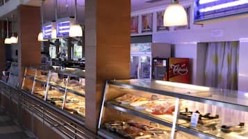 A buffet area with various food options, a refrigerator, and a beverage dispenser.
