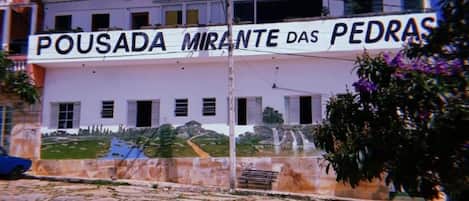 A building with a sign reading 'POUSADA MIRANTE DAS PEDRAS'.