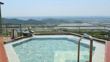 A rooftop swimming pool with a clear view of the surrounding landscape.