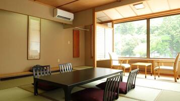 A traditional Japanese-style room with tatami flooring, a low table with cushions, and sliding doors.