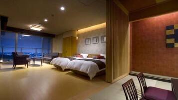 A hotel room with a large bed, a seating area, and a view of the city.