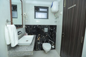 A bathroom with a white sink, a toilet, a mirror, and a towel rack.