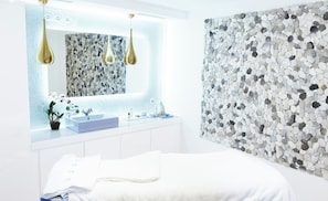 A modern bathroom with a white sink, a mirror, and a wall with a pebble pattern. - Le Chalet D'adrien (Bagnes)