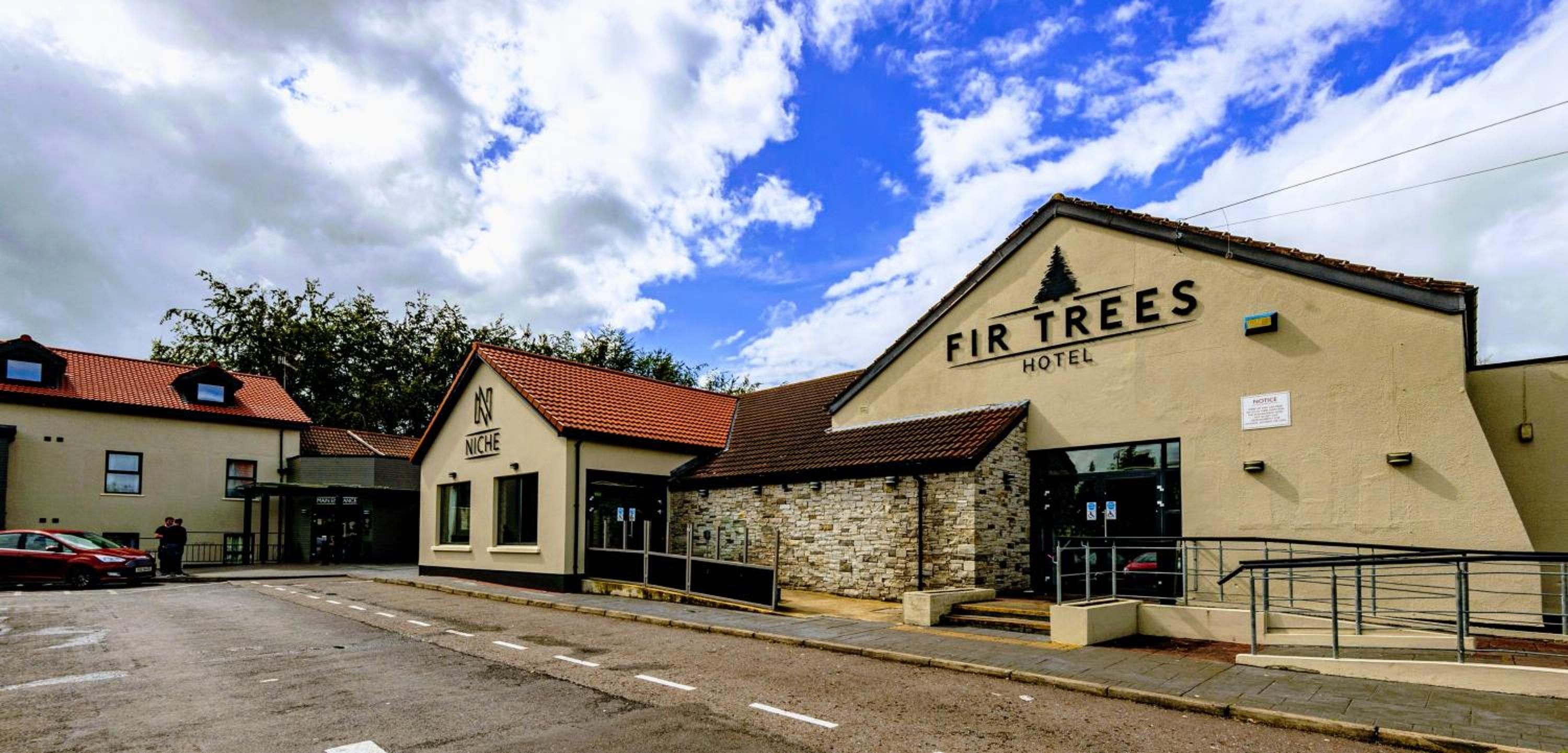 A hotel named 'FIR TREES' with a stone facade and a red-tiled roof.