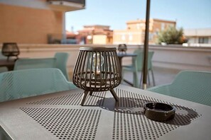 A metal table with a perforated metal tablecloth, a candle holder, and a small bowl on the table. - Castrichella Boutique Hotel (Fiumicino)