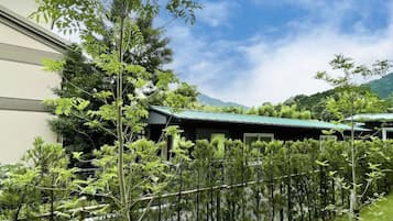 A building with a green roof, surrounded by a variety of trees and shrubs.