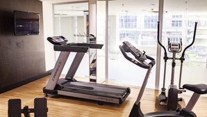 A gym with treadmills, an elliptical, and a stationary bike. - D Luca Hotel (Cuiabá)