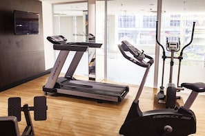 A gym with treadmills, an elliptical, and a stationary bike. - D Luca Hotel (Cuiabá)