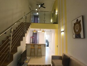 A modern interior with a staircase, a dining area, and a living space.