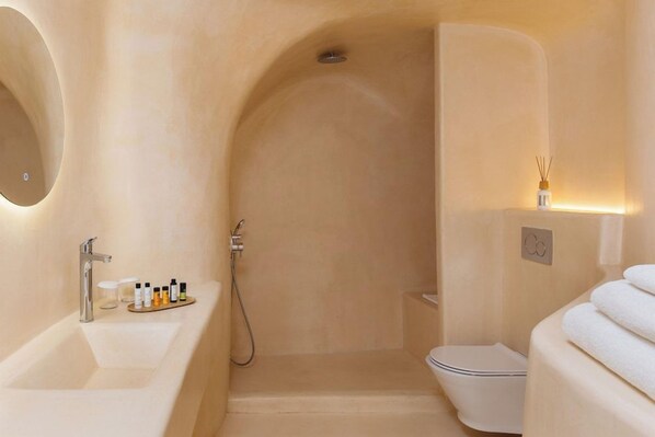 Un baño moderno con bañera, inodoro y zona de ducha.