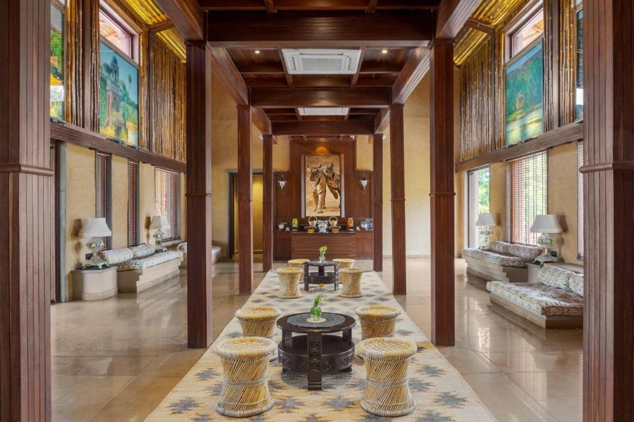 A hallway with a central fire feature, seating areas on either side, and artwork on the walls.