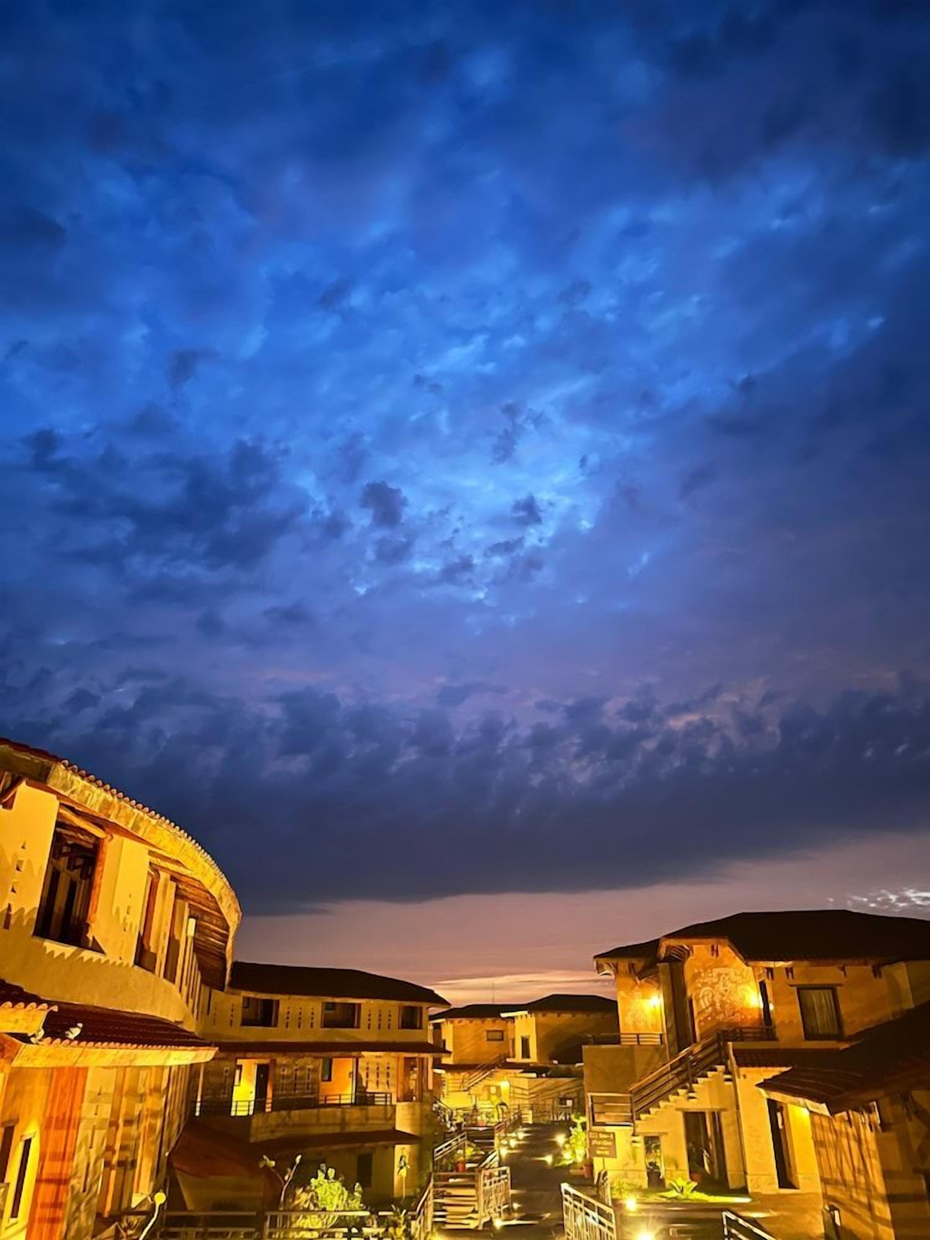 A courtyard with buildings, a staircase, and a view of the sky.