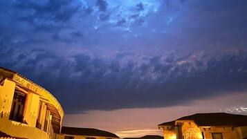 A courtyard with buildings, a staircase, and a view of the sky.