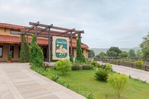 Un hotel con un letrero, un camino pavimentado y vistas del paisaje circundante.