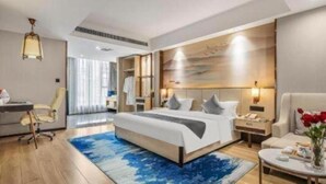 A hotel room with a large bed, bedside tables, a desk, and a chair. - Greentree Eastern Kunming Baiyun Road Tongde Square Hotel (Kunming)