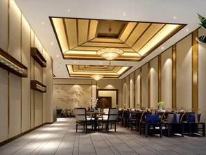 Uma área de refeições de hotel moderna, com uma mesa comprida, cadeiras e teto decorativo.