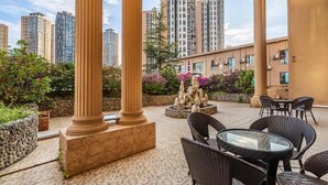 An outdoor patio area with columns, seating, and a decorative stone feature. - Greentree Eastern Kunming Baiyun Road Tongde Square Hotel (Kunming)