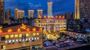 A hotel with multiple floors, a parking lot, and surrounding high-rise buildings. - Greentree Eastern Kunming Baiyun Road Tongde Square Hotel (Kunming)