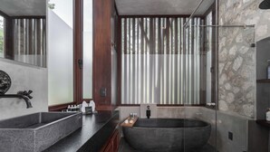 Un baño moderno con una bañera independiente, un lavabo doble y una ducha con cerramiento de vidrio.