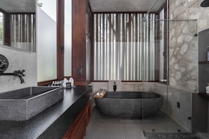 Une salle de bain moderne avec une baignoire sur pieds, un meuble-lavabo à deux vasques et une douche à parois de verre.