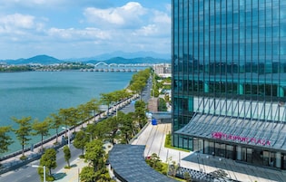 Un edificio moderno con fachada de vidrio y un letrero que dice 'CROWN PLAZA'.