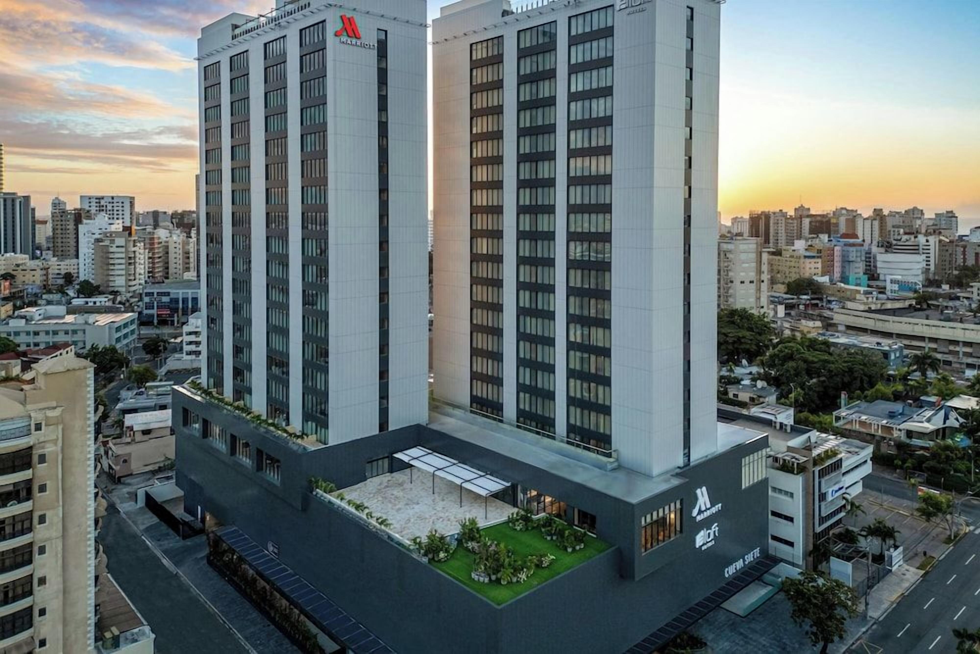 A high-rise hotel with multiple floors, a rooftop garden, and a modern architectural design.