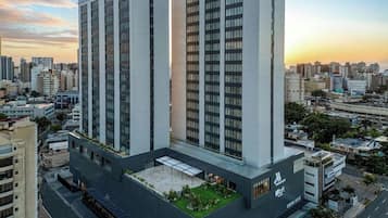 A high-rise hotel with multiple floors, a rooftop garden, and a modern architectural design.