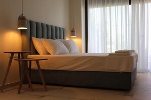 Un dormitorio moderno con cama, mesitas de noche y ventana con cortinas.
