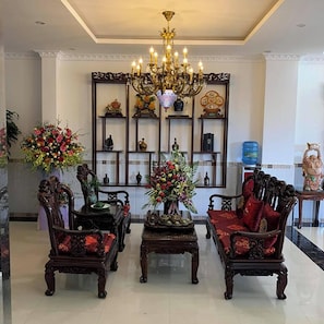 Ein traditionelles Interieur mit aufwendigen Möbeln, einer Chandelüster und dekorativen Regalen.