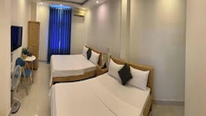 A hotel room with two beds, a desk, a chair, and a TV. - Tuan Anh 2 Hotel by Zuzu (Dong Thuan)
