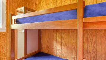 Un lit superposé avec un matelas bleu dans une pièce en bois.