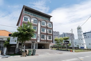 A multi-story building with a modern design, featuring a garage entrance and a bell tower. - Swing & Pillows AT Klebang, Melaka (Malacca City)