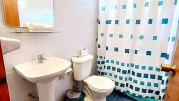 A bathroom with a sink, toilet, and shower curtain.