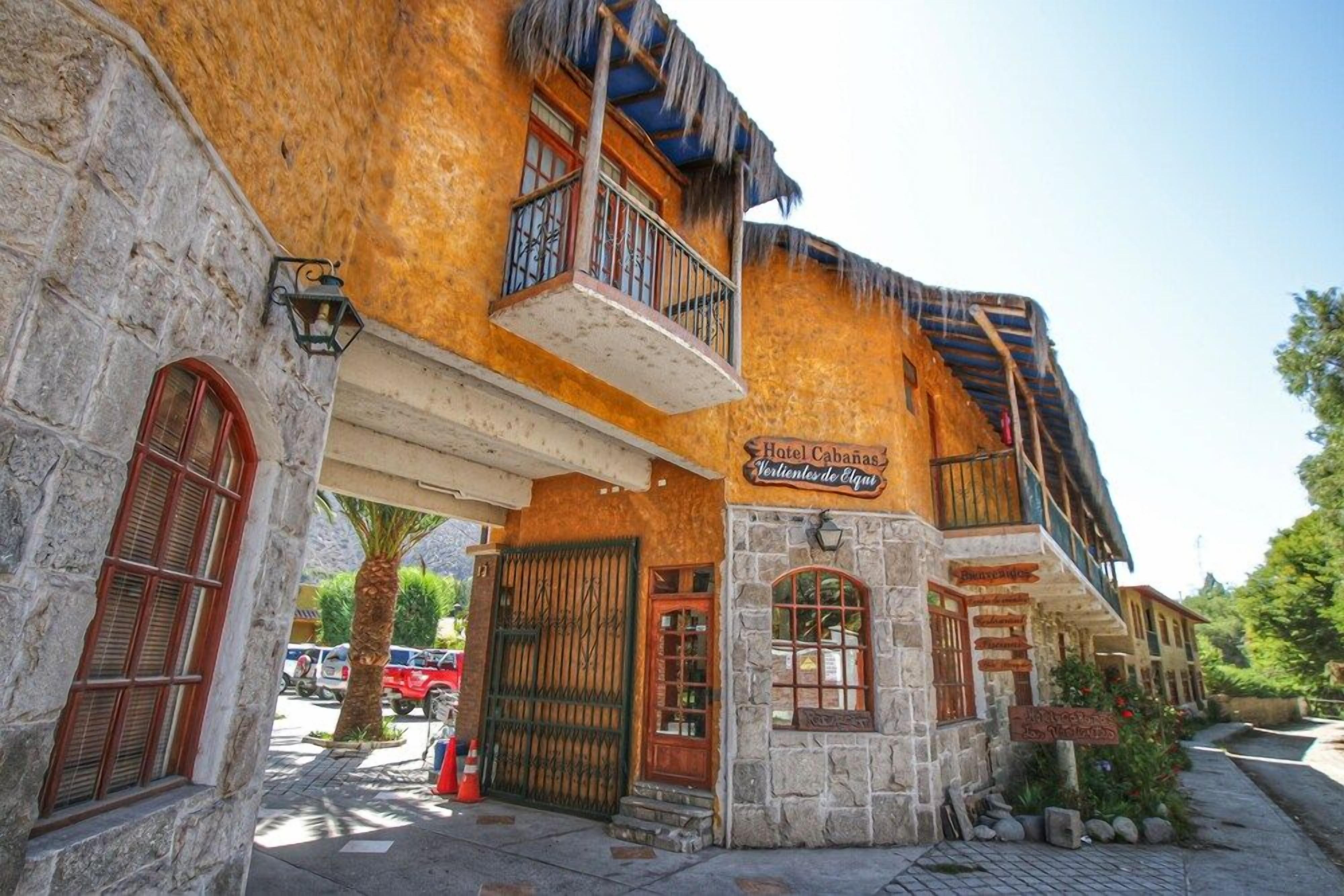A building with a stone facade, a balcony, and a sign that reads 'Hotel Cabanas Venturales de Elqui.'