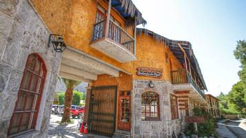 A building with a stone facade, a balcony, and a sign that reads 'Hotel Cabanas Venturales de Elqui.'