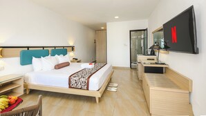 Ein Hotelzimmer mit einem Bett, einem Schreibtisch, einem Fernseher und einem durch eine geöffnete Tür einsehbaren Badezimmer.