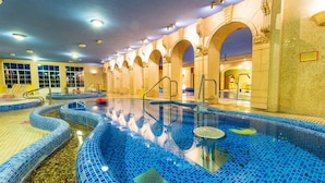 Una piscina cubierta con varias pistas, agua cristalina y suelo de baldosas.