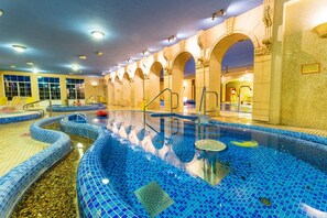 An indoor swimming pool with multiple lanes, clear water, and a tiled floor. - Hotel Bellevue (Esztergom)
