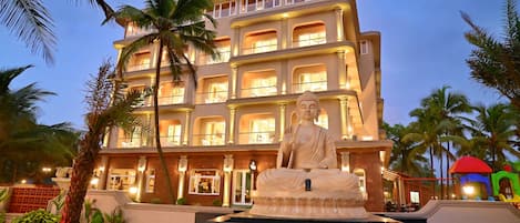 Un hotel de varios pisos con una estatua en el patio.