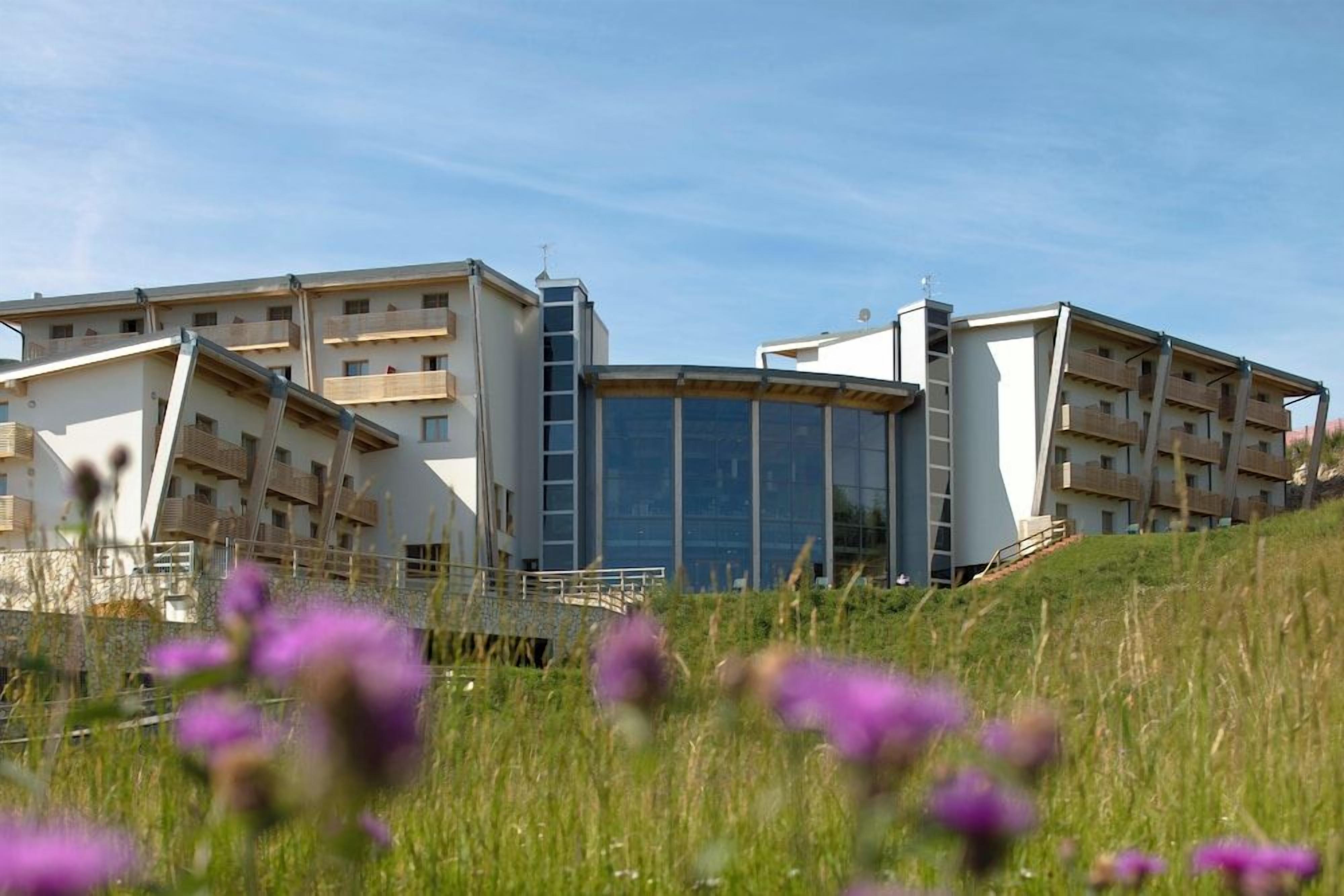 A modern building with multiple balconies and a glass facade.