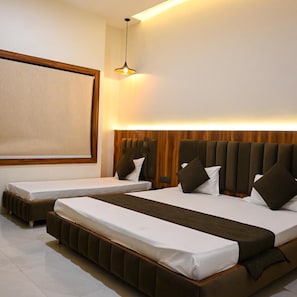 A hotel room with two beds, a large mirror, and a modern pendant light. - Hotel Kedar Dham (Mathura)