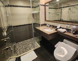 A modern bathroom with a glass-enclosed shower, a sink with a towel rack, and a toilet. - Royal Guest Hotel (Tainan)