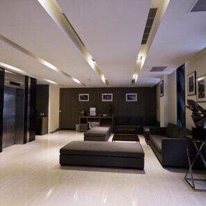 A modern living room with a sofa, ottoman, and coffee table. - Royal Guest Hotel (Tainan)