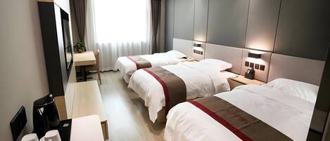 A hotel room with two beds, a desk, and a coffee machine.