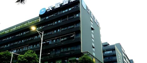 A multi-story hotel with a modern facade, multiple balconies, and a prominent signage indicating it is a hotel.