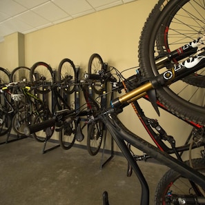 A bicycle storage area with multiple bikes and a bike rack. - Burke Mountain Hotel and Conference Center (East Burke)